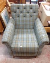 A vintage box framed armchair with green tartan button back upholstery, set on turned front legs