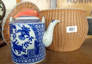 A vintage ceramic Chinese blue and white teapot in woven plastic basket