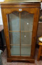 A 61cm vintage walnut display cabinet with glass shelves enclosed by a glazed panel door, set on