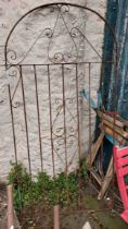 An old wrought iron garden gate of scroll design