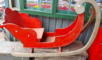 A red and green painted wooden decorative sledge