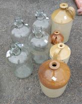 Four stoneware flagons and four glass demi johns