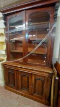 A 1.33m Victorian mahogany two part book cabinet with flanking brackets to cornice and adjustable