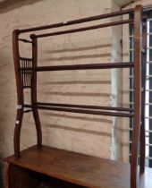 An Edwardian mahogany double towel rail with flanking slender spindle decoration and swept supports