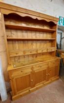 A 1.6m modern pine two part dresser with three shelf open plate rack and four spice drawers over a