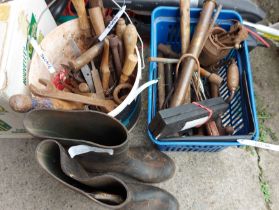A bucket and blue crate containing a quantity of old tools including sharpening stone, spanners,