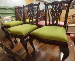 A set of four Chippendale style mahogany framed ribbon back dining chairs with upholstered drop-in