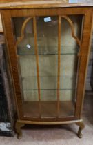 A 58cm 1930's walnut display cabinet with glass shelves enclosed by a beaded glazed panel door,