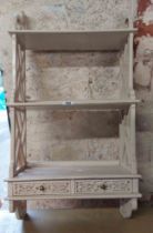 A 47cm white painted wood wall mounted three shelf open unit with two blind fretwork decorated