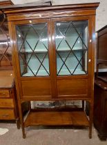 A 1.04m Edwardian inlaid mahogany display cabinet with material lined shelves enclosed by a pair