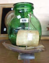 A small green glass carboy - sold with a model ship made from cow horn