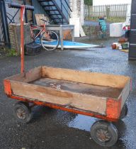 An articulated trolley with plywood bed and long handle