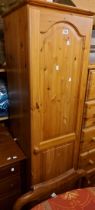 A 45cm modern pine hall wardrobe with hanging space enclosed by a panelled door