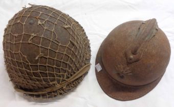 Two military tin helmets, one a French M1915 Adrian pattern, the other with string netting