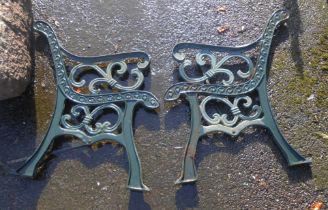 A pair of green painted cast iron bench ends