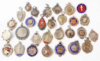 A bag containing a collection of silver and white metal sporting and other fobs, some with enamel