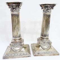 A pair of 17cm high silver Corinthian column candlesticks with swag decoration to the loaded