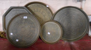 Five Eastern brass trays of various size with chased decoration