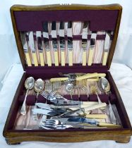 A vintage polished oak canteen containing a part set of silver plated cutlery