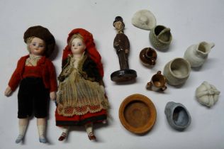 A bag containing two small bisque porcelain costume dolls and a quantity of miniature items