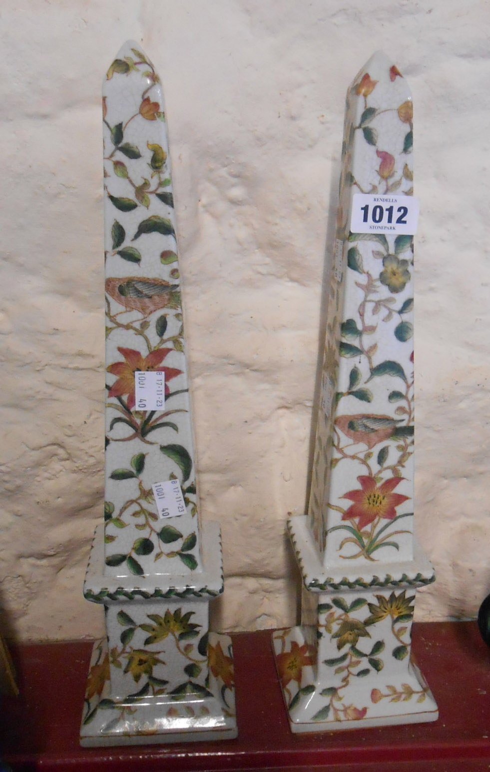 A pair of modern porcelain obelisks decorated with birds amidst foliage on a crackle glazed finish