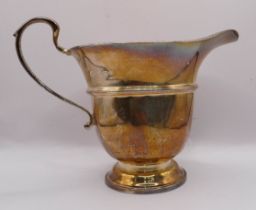 An 8cm high silver cream jug with beaded rim and footed base - Birmingham 1932, by Adie Brothers