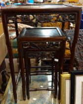 Three Chinese rosewood nesting tables from a quartetto set with decorative pierced friezes, set on