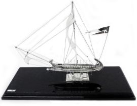 A 15cm white metal model of a Greek war galley with rigging and cast stand, set in a perspex display