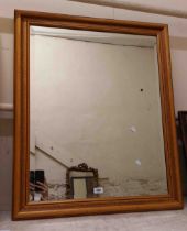 A modern stained wood framed bevelled oblong wall mirror