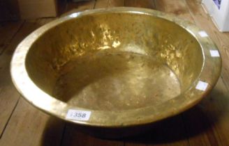 A large antique brass cream bowl