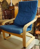 A modern bentwood framed armchair with blue upholstered cushions