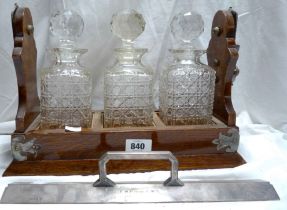 A antique oak tantalus with three cut glass decanters - a/f