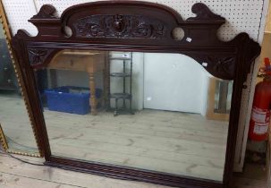 A 1.4m Edwardian stained walnut framed overmantel mirror with carved decoration to pediment and