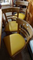 A set of four vintage kitchen chairs with yellow vinyl seats