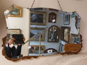 A vintage frameless wall mirror with bevelled shield shaped plate and applied wooden detail