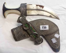 An Omani dagger of curved form with embossed metal scabbard