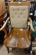 A late Victorian oak framed open armchair with button back upholstered panel and solid moulded seat,