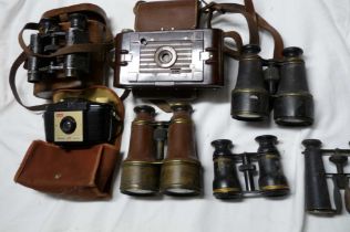 A box containing a quantity of vintage field glasses and cameras