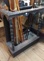 A late Victorian carved oak stick stand with bobbin turned front supports and metal drip tray