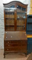 A 93cm early 20th Century walnut two part bureau/bookcase with adjustable shelves enclosed by a pair