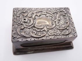 A Chester silver matchbox stand with embossed decoration to top and loaded plinth base