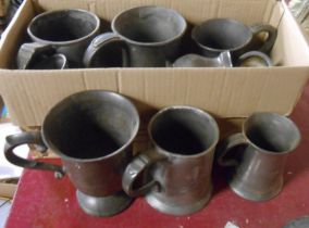 A box containing a quantity of Victorian pewter tankards and measures