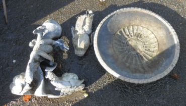An antique lead pedestal bird bath with dished circular top, set on a classical dolphin pattern