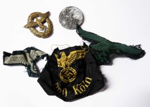 A bag containing three Nazi patches, a pin badge and a tie pin