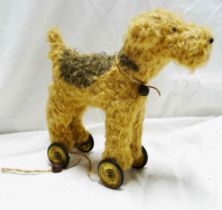 An old pull-along plush toy depicting a short haired terrier set on Meccano base