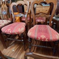 A set of six Victorian mahogany framed dining chairs with shaped top rails and upholstered seats,