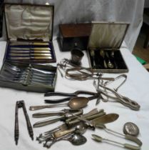 A box containing a quantity of silver plate and collectable items including nut crackers, tongs,