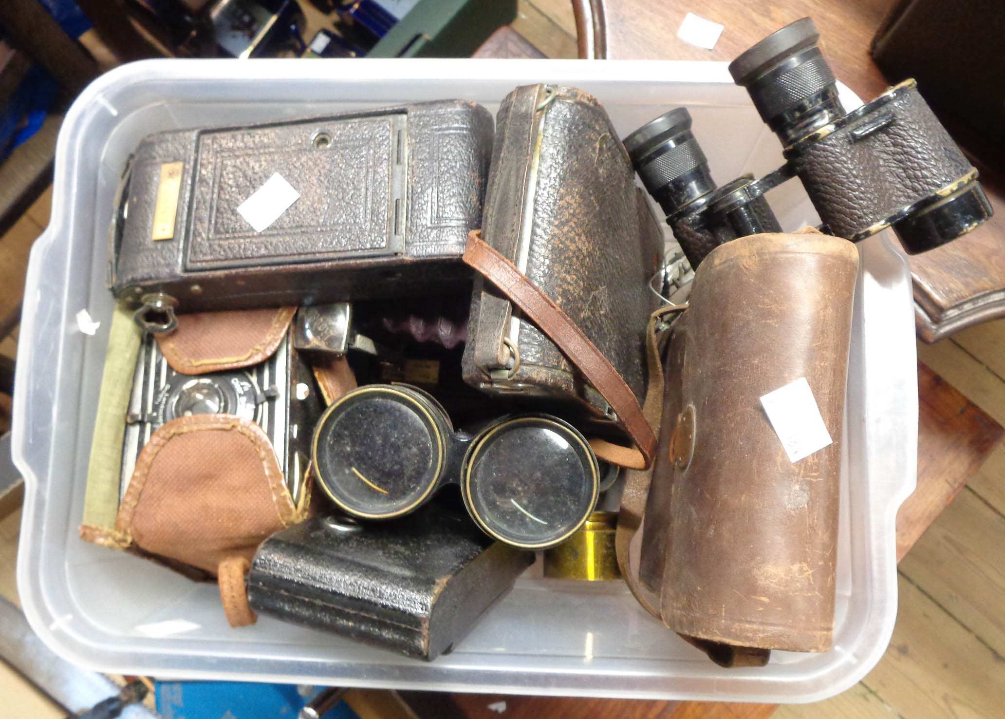 A small crate containing a quantity of old cameras, binoculars, etc.