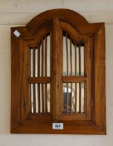 A modern Eastern stained wood framed wall mirror with pair of stick panelled doors to front and