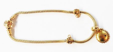 A genuine Pandora 585 (14ct.) gold snake-link bracelet with one charm and two charm suspenders -